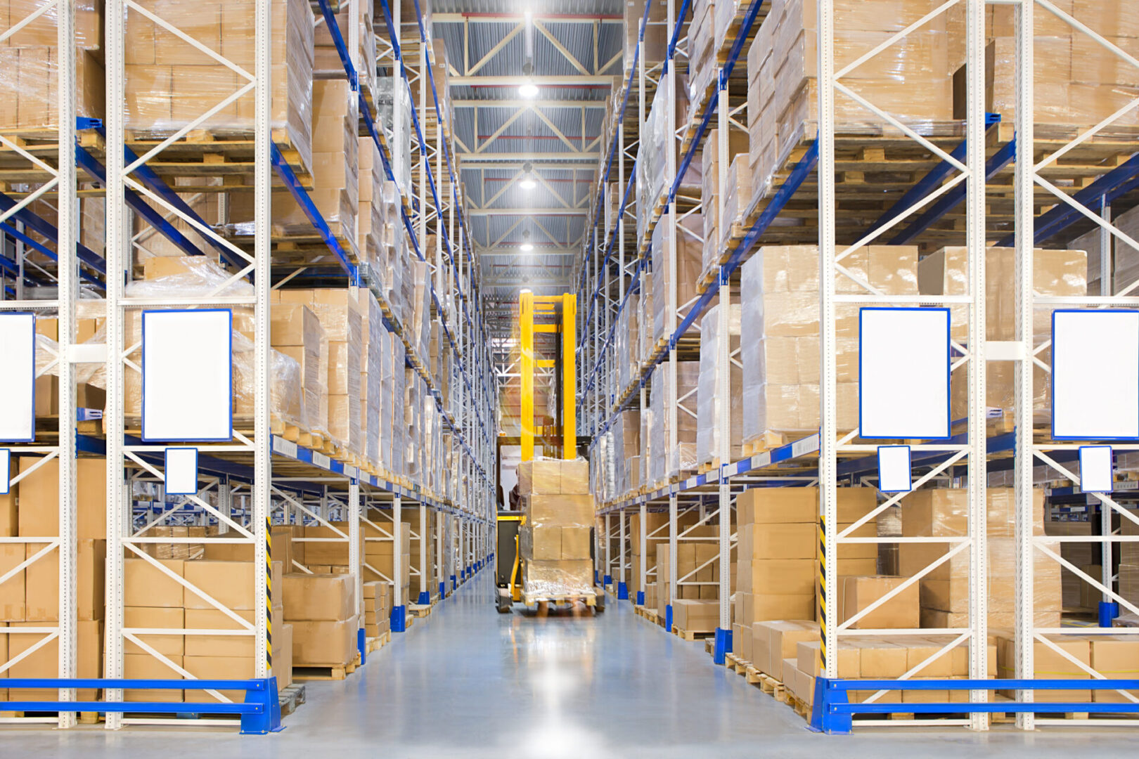 A large distribution warehouse with yellow forklift
